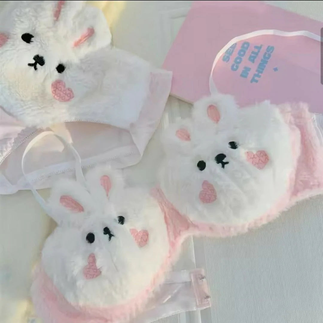 Set of white bunny face masks with pink accents on a light background
