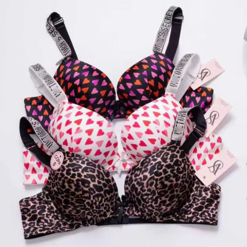 Collection of patterned bras with visible brand labels on a white background