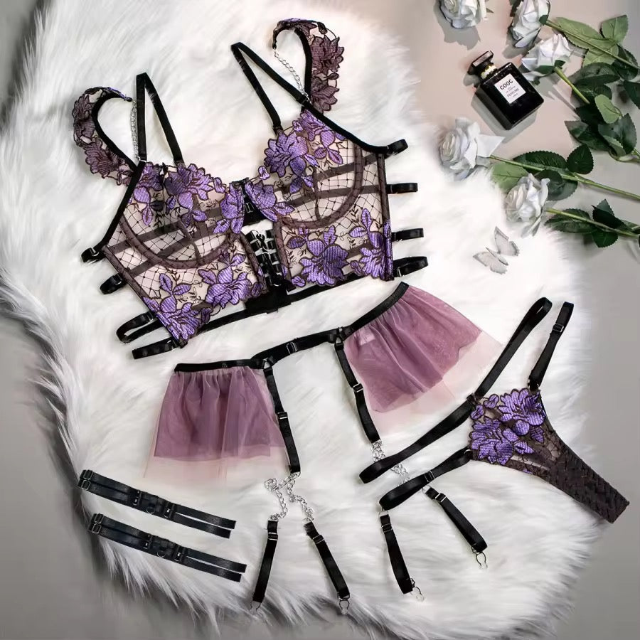Lace lingerie set with purple floral details on a white fur background.