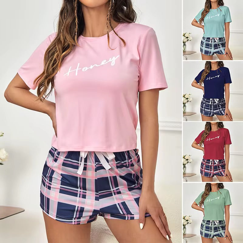 Woman wearing a pink 'Honey' t-shirt and plaid shorts with additional color options displayed.