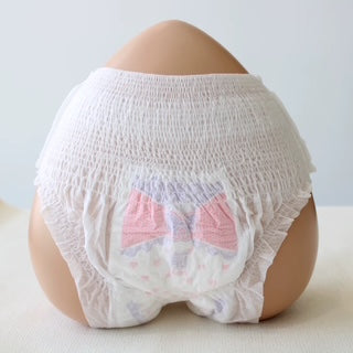White baby bloomers with pink accents on a neutral background
