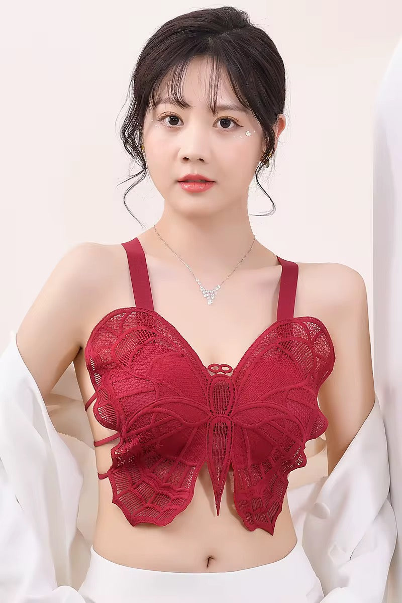 Woman wearing a red lace bralette against a white background