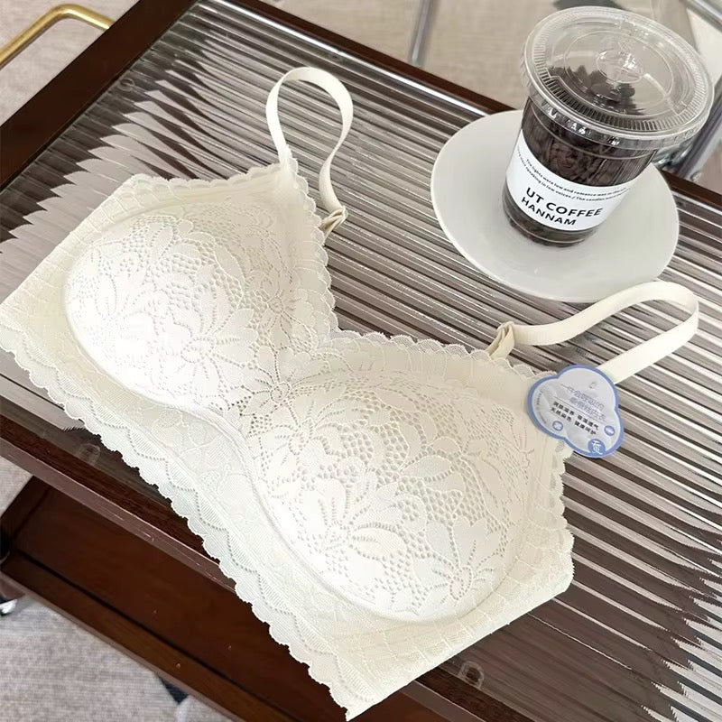 White lace bra on a metal tray with a coffee cup in the background