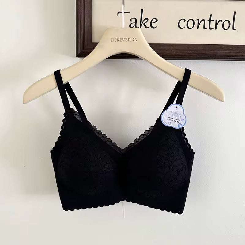 Black bralette with lace details on a hanger against a white background