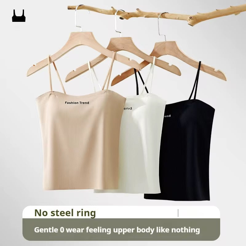 Three spaghetti strap tops in beige, white, and black hanging on wooden hangers against a light gray background.