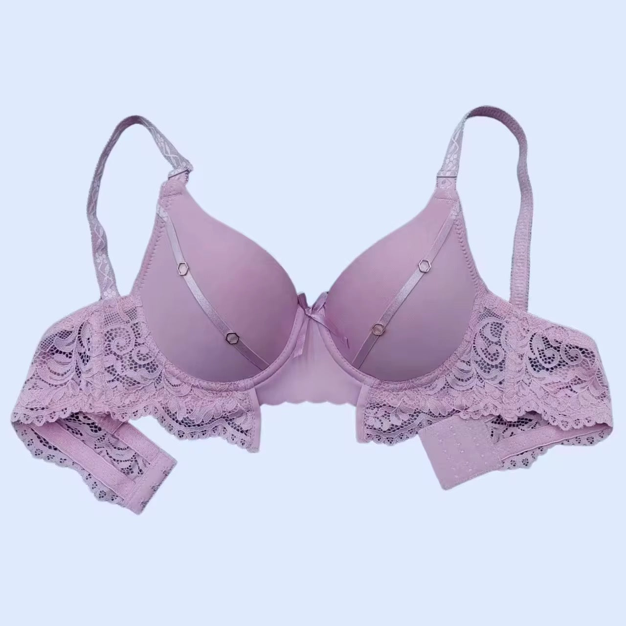 Pink bra and panties set with lace details on a light blue background