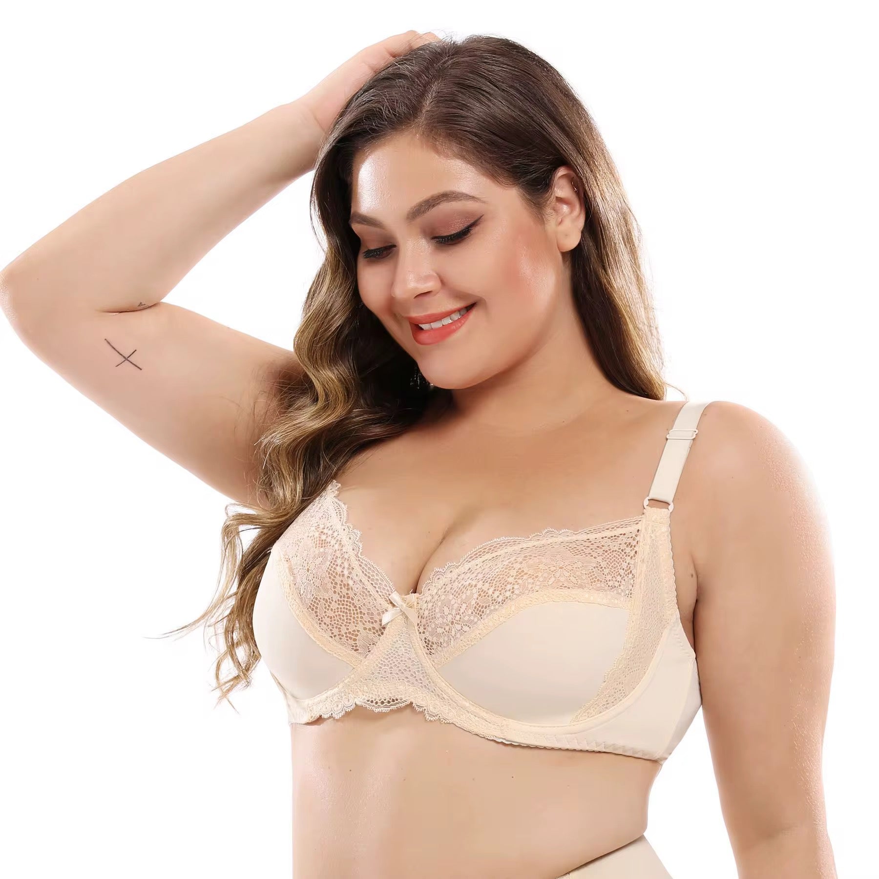Woman wearing a beige lace bra on a white background