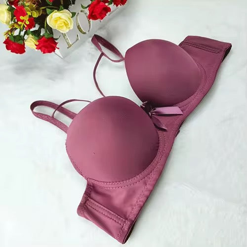 Pink bra on a white background with flowers in the corner