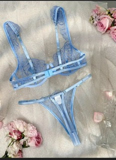 Blue lingerie set with floral decorations on a light background