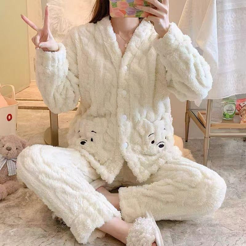 Person wearing a fluffy white pajama set with cartoon characters, sitting on a couch.