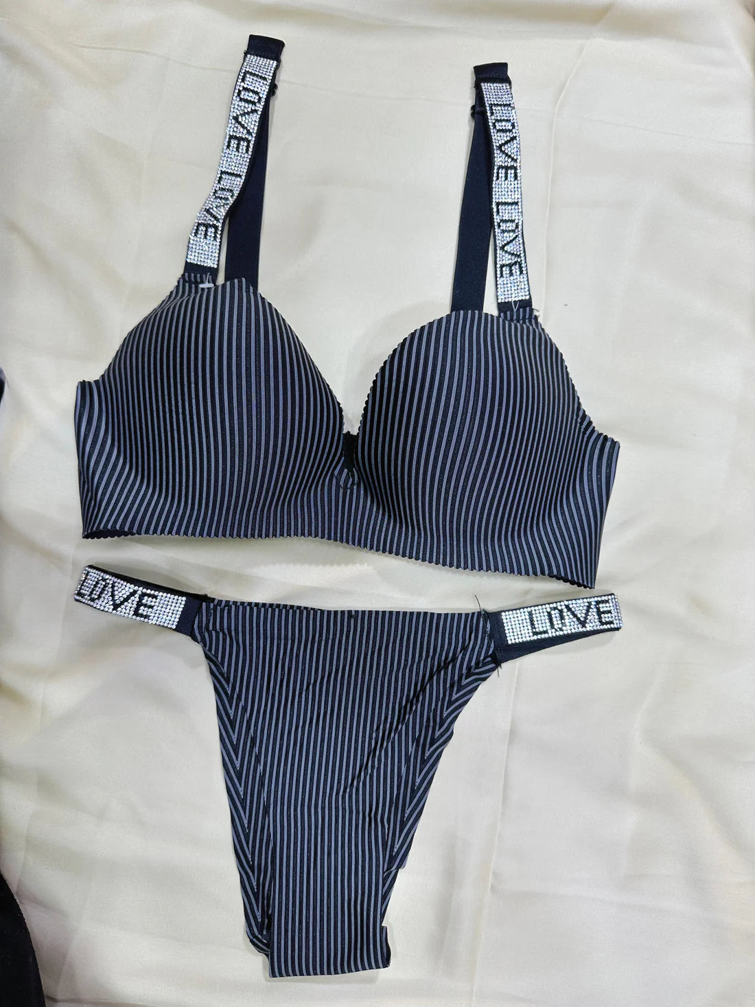 Black and white striped lingerie set with 'LOVE' waistbands on a white background