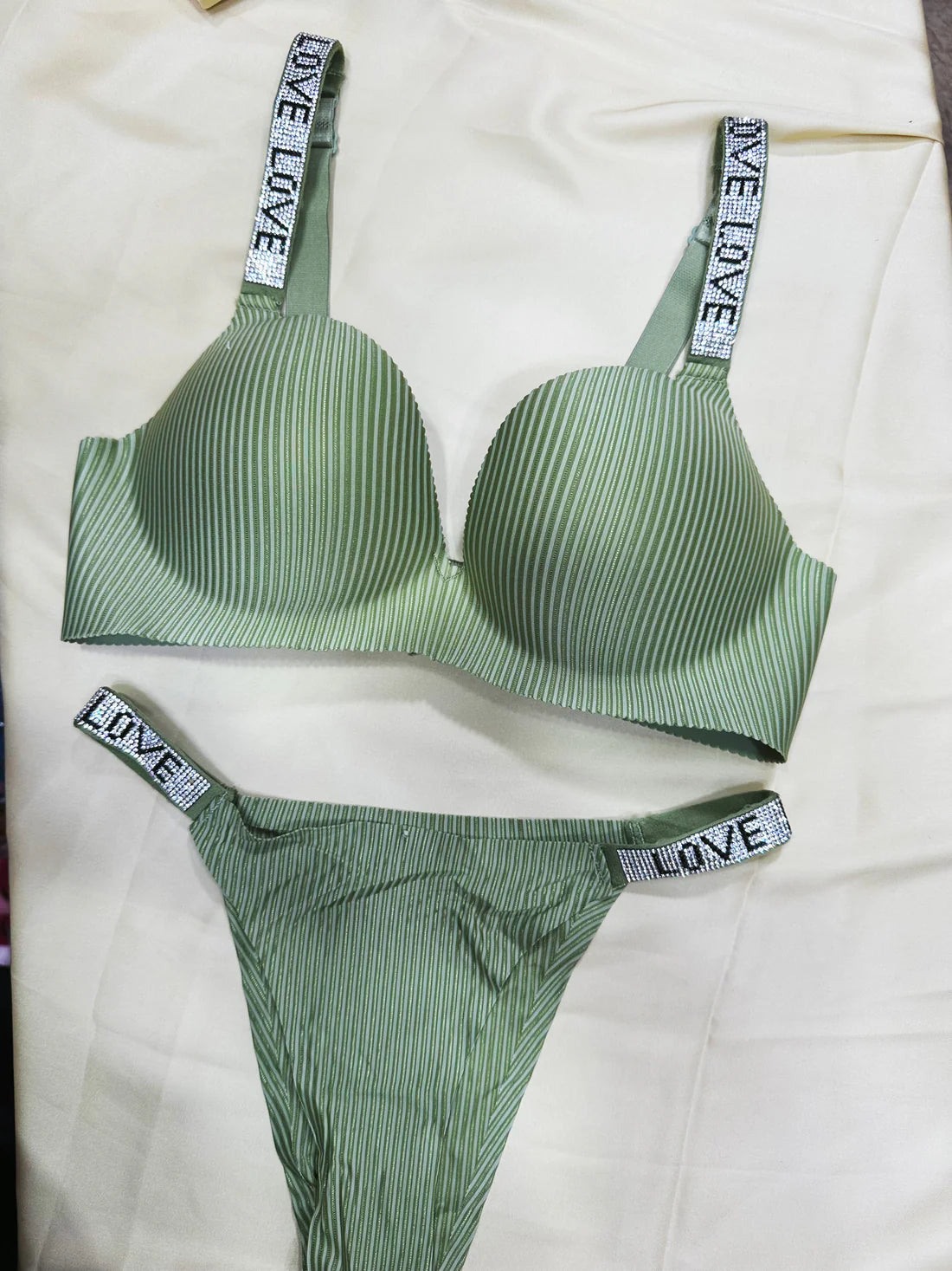 Green striped bra and panties set with 'LOVE' straps on a white background