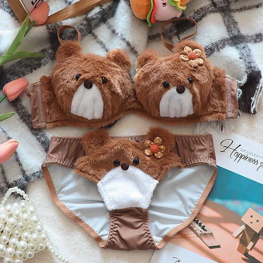Brown teddy bear-themed underwear set on a textured surface with decorative items.