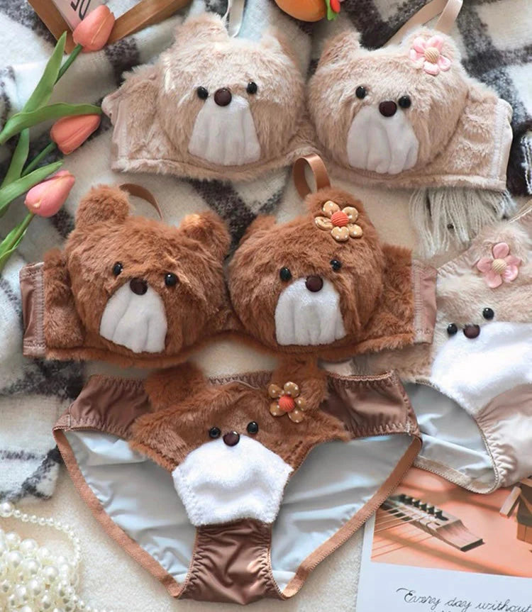 Set of teddy bear-themed bras and panties on a patterned fabric background.