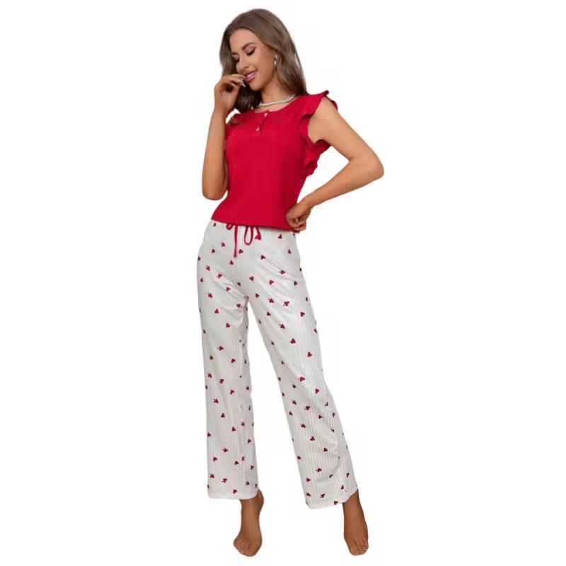 Woman wearing a red top and white pants with red heart patterns on a white background