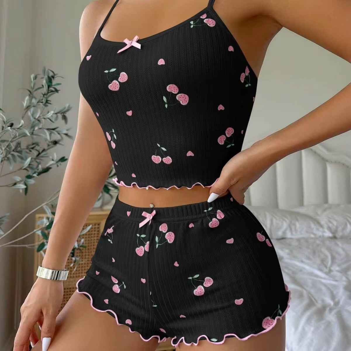 Black ribbed tank top and shorts set with pink floral patterns on a neutral background