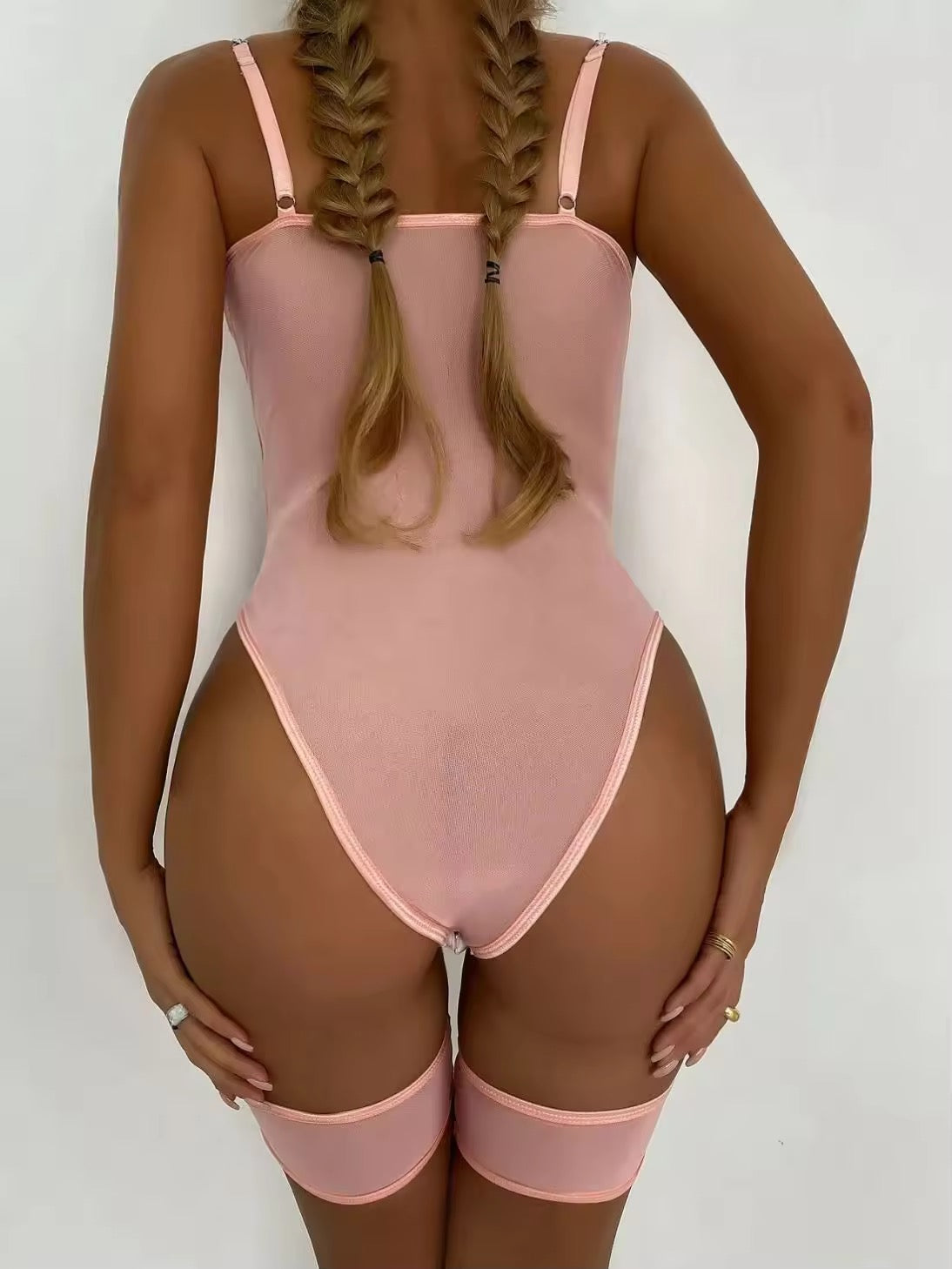 Person wearing a pink bodysuit against a white background