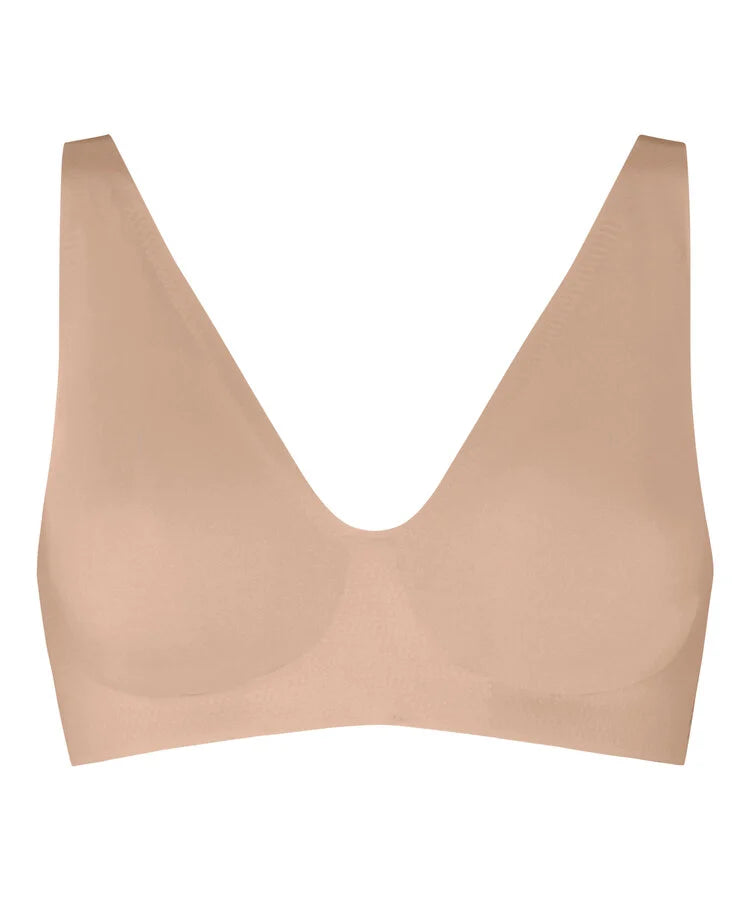 A seamless, solid-colored bralette in a light peach-beige shade, shown against a plain white background.