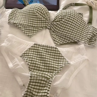 A two-piece bikini set with a green and white gingham check pattern, featuring a ruffled bow detail on the bra top and matching ruffled side ties, laid flat on a white fabric background.