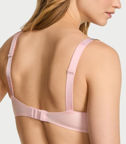 A close-up back view of a woman wearing a light pink wireless bra with adjustable straps and a hook-and-eye closure.