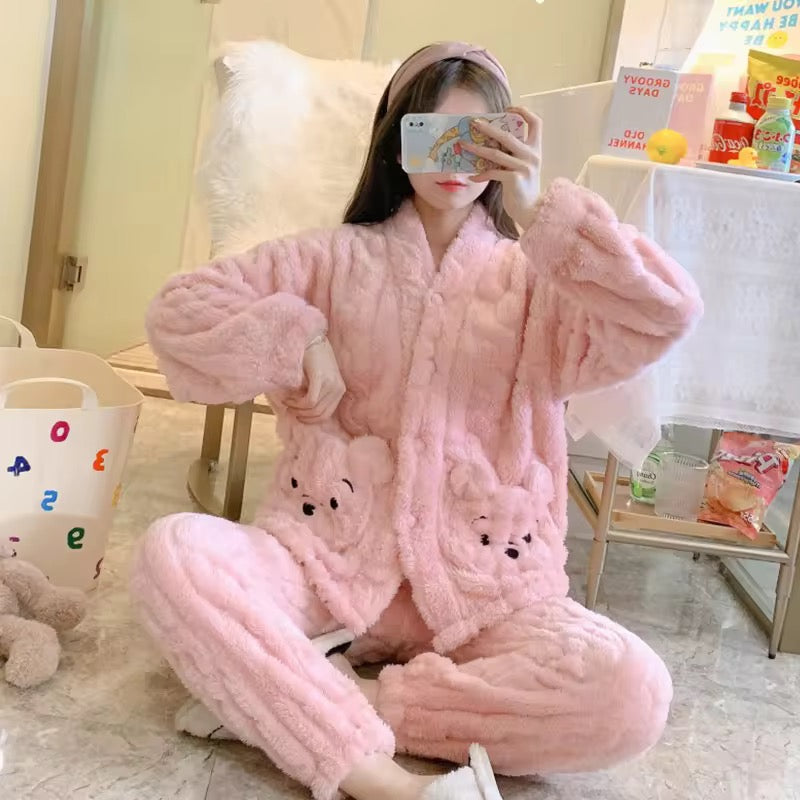 Person wearing a pink plush robe with bear designs in a room.