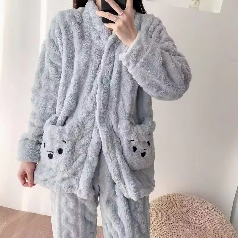 Person wearing a gray plush robe with bear face pockets.