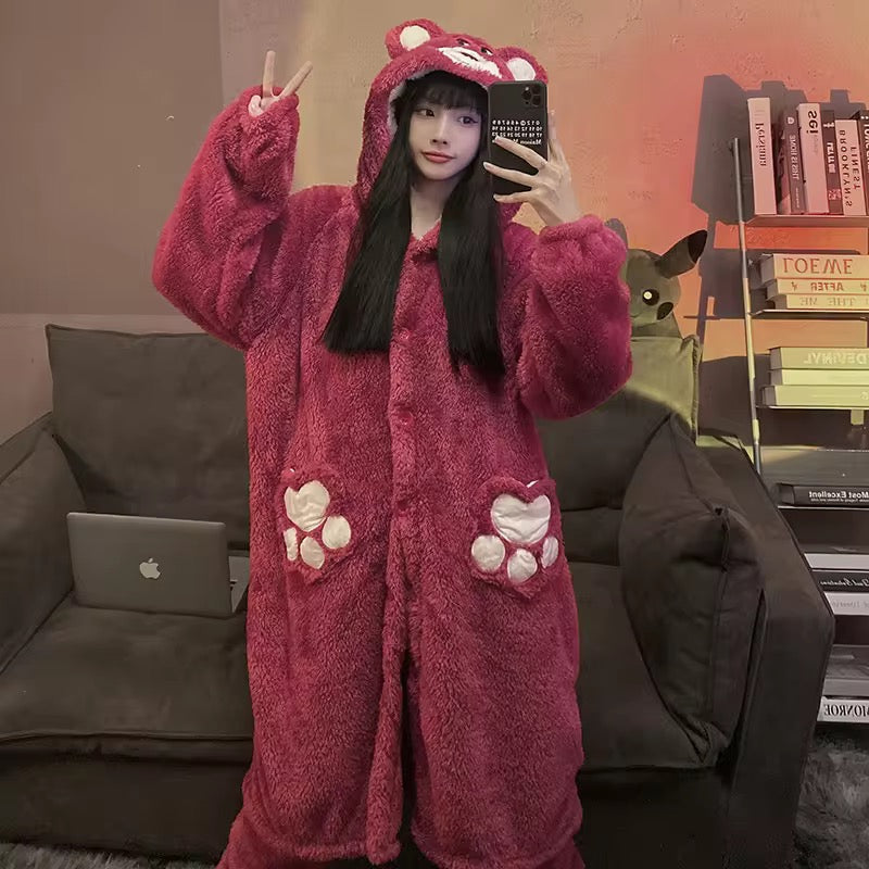 Person wearing a pink plush robe with animal ears and paw prints, taking a selfie in a room.