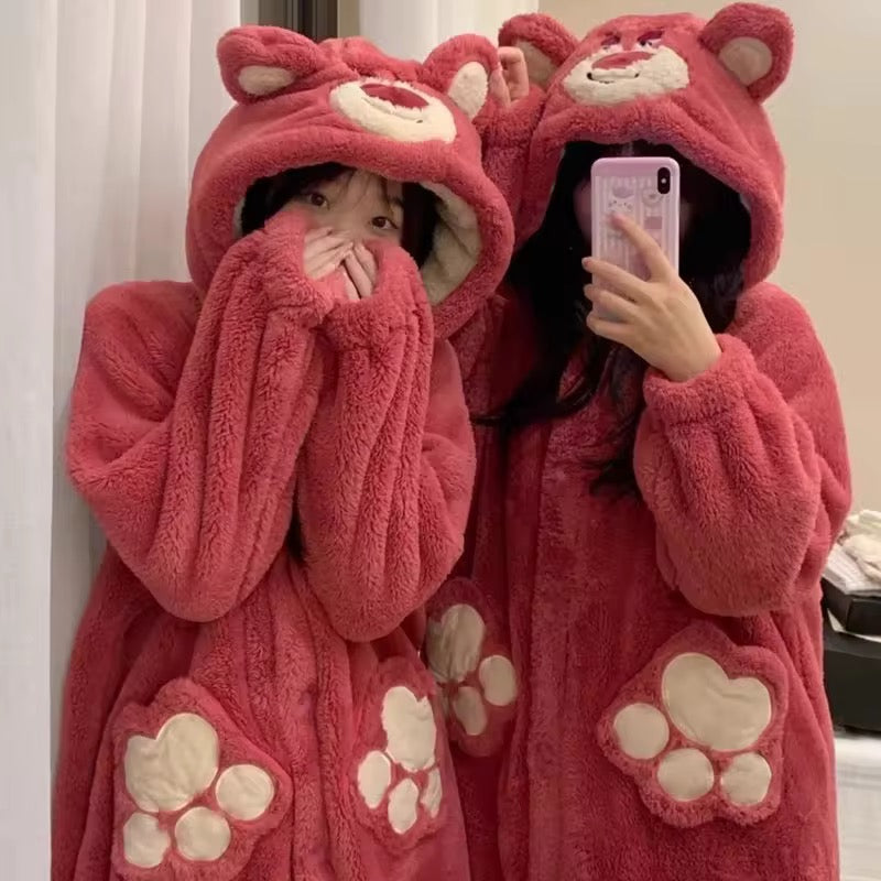 Two people wearing pink bear-themed robes taking a mirror selfie.