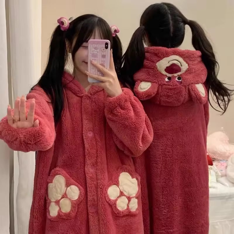 Person wearing a pink plush robe with paw designs, taking a mirror selfie.